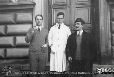 Histologikursen höstterminen 1925 i Lund
Album från histologikursen höstterminen 1925 i Lund. Albumtext: "Talar för sig själv".  Troligen amanuens Einar Andersson i mitten. De andra kan kanske vara några av de andra amanuenserna enligt universitetskatalogen, Alf Sjövall f. 1905,  Helge Sjövall f. 1904 eller Toivo Svaetichin (senare Stenstam) f. 1904. Foto på anatomiska institutionens entrétrappa på Biskopsgatan 7. Bildkälla Locus Medicus Lundensis 2025-03-17. Fotograf okänd.
Nyckelord: Laboratorium;Histologiska avdelningen;Anatomiska Institutionen;Sydsvenska Medicinhistoriska Sällskapet;Medicinska fakulteten;Locus Medicus Lundensis;Lunds