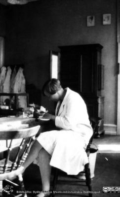 Fotoalbum tillägnat Professor Torsten Hellman från histologkursen 1929
Fotoalbum tillägnat Professor Torsten Hellman med tacksamhet och vördnad från histologkursen 1929. Bildtext "Gunborg Nordh". 
Rimligen en kursdeltagare i kurslaboratoriet. 
- Gunborg Nordh (1908 - 1999) gifte sig 1934 med kurskamraten Carl-Erik Uddenberg. Hon disputerade 1955 i Lund på en avhandling om diagnostik på prematurt förlösta barn. Hon hade dessförinnan arbetat med medicinsk kemi i ett laboratorium men också på barnklinik och inom psykiatri. Från 1949 var hon ansvarig för den barnpsykiatriska avdelningen på Lasarettet i Lund.
Nyckelord: Anatomiska Institutionen;Histologiska avdelningen;Mikroskopering;Medicinska fakulteten i Lund;Locus Medicus Lundensis;Universitet