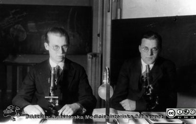 Fotoalbum tillägnat Professor Torsten Hellman från histologkursen 1929
Fotoalbum tillägnat Professor Torsten Hellman med tacksamhet och vördnad från histologkursen 1929. Bildtext "Sven Rohlin. Rolf Mellander.  ". 
Rimligen kursdeltagare vid sina mikroskop  och objektsglaslådor i kurslaboratoriet.
- Sven Rohlin (1908 - 1982) var internmedicinare och tbc-läkare, sedan 1952 poliklinikläkare på Södersjukhuset i Stockholm.
- Rolf Mellander (1908-1993) var centraldispensärläkare i Västerås sedan 1968.
Nyckelord: Histologiska avdelningen;Anatomiska Institutionen;Kurslaboration;Medicinska fakulteten i Lund;Locus Medicus Lundensis;Universitet