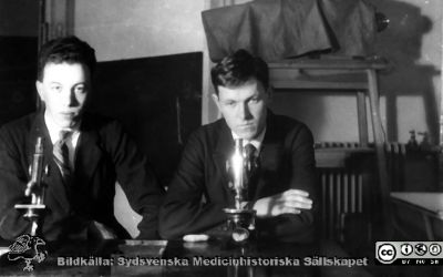 Fotoalbum tillägnat Professor Torsten Hellman från histologkursen 1929
Fotoalbum tillägnat Professor Torsten Hellman med tacksamhet och vördnad från histologkursen 1929. Bildtext "Thure A Nilsson, Yngve Siver ". 
Rimligen kursdeltagare vid sina mikroskop  och objektsglaslådor i kurslaboratoriet.
Inget är känt om dessa elevers fortsatta verksamheter.
Nyckelord: Histologiska avdelningen;Anatomiska Institutionen;Medicinska fakulteten i Lund;Locus Medicus Lundensis;Universitet;Kurslaboration
