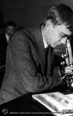 Fotoalbum tillägnat Professor Torsten Hellman från histologkursen 1929.
Fotoalbum tillägnat Professor Torsten Hellman med tacksamhet och vördnad från histologkursen 1929. Bildtext "Bengt Franzén ". 
Rimligen kursdeltagare vid mikroskop  och objektsglaslåda i kurslaboratoriet.
Bengt Franzén (1907 - 1997) var efter tjänstgöringar som psykiatriker i Sydsverige från 1958 överläkare i hjälpverksamheten på Gullberna Sjukhus i Karlskrona.
Nyckelord: Histologiska avdelningen;Anatomiska Institutionen;Medicinska fakulteten i Lund;Locus Medicus Lundensis;Universitet;Kurslaboration