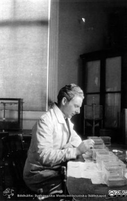 Fotoalbum tillägnat Professor Torsten Hellman från histologkursen 1929.
Fotoalbum tillägnat Professor Torsten Hellman med tacksamhet och vördnad från histologkursen 1929. Bildtext "Arne Eggert". 
Rimligen kursdeltagare  i kurslaboratoriet i färd med att färga objektsglas i glasvannor.
 -Arne Eggert (1908 - 1991). Efter olika internmedicinska tjänstgöringar blev han praktiserande läkare i Stockholm från 1947, distrikts-  och tf tjänsteläkare i Enskede 1952 - 1964 och praktiserande i staden sedan 1964.
Nyckelord: Histologiska avdelningen;Anatomiska Institutionen;Medicinska fakulteten i Lund;Locus Medicus Lundensis;Universitet;Kurslaboration