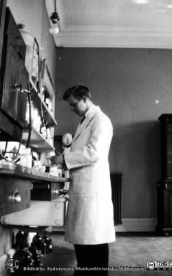 Fotoalbum tillägnat Professor Torsten Hellman från histologkursen 1929.
Fotoalbum tillägnat Professor Torsten Hellman med tacksamhet och vördnad från histologkursen 1929. Bildtext "Sten Axtrup". 
Rimligen kursdeltagare  i kurslaboratoriet vid en arbetsbänk.
Sten Axtrup (1907 - 2000) disputerade  1956 i pediatrik i Lund. Han var lasarettsläkare i pediatrik i Kristianstad från 1949.
