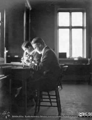 Fotoalbum tillägnat Professor Torsten Hellman från lärjungar under Kursen 1924 - 25
Fotoalbum tillägnat Professor Torsten Hellman från lärjungar under Kursen 1924 - 25. Två män vid ett bord med ett mikroskop.  Troligen visar bilden två unga medicine studerande De är inte identifierade. Ingen bildtext.
Bildkälla Stiftelsen Locus Medicus Lundensis 250317. Fotograf okänd.
Nyckelord: Histologiska avdelningen;Anatomiska Institutionen;Medicinska fakulteten i Lund;Sydsvenska Medicinhistoriska Sällskapet;Locus Medicus Lundensis;Lärare