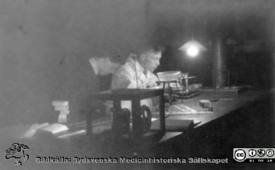 Fotoalbum tillägnat Professor Torsten Hellman från lärjungar under Kursen 1924 - 25
Fotoalbum tillägnat Professor Torsten Hellman från lärjungar under Kursen 1924 - 25. Två unga män i i nattligt arbete i ett histologiskt laboratorium med olika apparater. Den bortre mannen bär laboratorierock och tycks hantera en enkel mikrotom. Den hitre mannen tycks föra anteckningar.  Rimligen är det två elever som lär sig göra preparat för mikroskopering. De är inte identifierade. Ingen bildtext.
Bildkälla Stiftelsen Locus Medicus Lundensis 250317. Fotograf okänd.
Nyckelord: Histologiska avdelningen;Anatomiska Institutionen;Medicinska fakulteten i Lund;Sydsvenska Medicinhistoriska Sällskapet;Locus Medicus Lundensis;Lärare;Elever