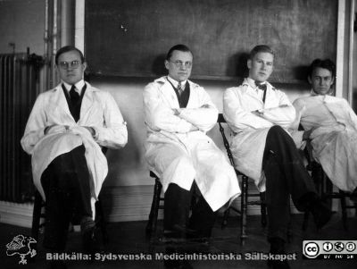 1928 års kurs i histologi i Lund
Fotoalbum märkt Histologikursen anno 1928. 
Detta album innehåller bilder från dåvarande histologiska avdelningen på anatomiska institutionen i Lund på Biskopsgatan 7. Liksom de övriga i serien skapades det av kursdeltagarna och tillägnades kursledaren, professor Torsten Hellman, som uppskattning av hans lärargärning. Bilden visar fyra amanuenser i avdelningens föreläsningssal. Längst till vänster troligen Erik Millbourn. Denne blev senare överläkare och chef på kirurgiska kliniken i Kalmar.  
Bildkälla Stiftelsen Locus Medicus Lundensis 250317.
Nyckelord: Locus Medicus Lundensis;Medicinska fakulteten i Lund;Histologiska avdelningen;Sydsvenska Medicinhistoriska Sällskapet;SMHS;Anatomiska Institutionen;Studenter;Lärare