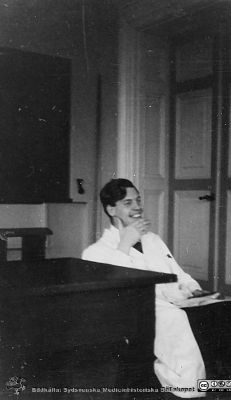 Bild i fotoalbum  tillägnat professor Torsten Hellman från deltagarna i histologikursen ht 1930. 
Fotoalbum  "TILL PROFESSOR TORSTEN hELLMAN MED TACK FRÅN DELTAGARNA I HISTOLOGIKURSEN HÖSTTERMINEN 1930".  Bildtext "MOBERG håller förhör. Vad skall jag nu fråga om? Svaret tycks bli roligt! Ja nästan mer än så! Men i alla fall var det rätt. När allt kommer omkring - det är ej så oävet att hålla förhör!".  Bildkälla stifteleen Locus Medicus Lundensis och Sydsvenska Medicinhistoriska Sällskapet / SMHS. Fotograf okänd.
Nyckelord: Histologiska avdelningen;Anatomiska Institutionen;Entrétrappa;Medicinska fakulteten i Lund;Sydsvenska Medicinhistoriska Sällskapet;Locus Medicus Lundensis;Lärare;Elever;Förhör