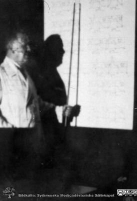Bild i fotoalbum  tillägnat professor Torsten Hellman från deltagarna i histologikursen ht 1930. 
Fotoalbum  "TILL PROFESSOR TORSTEN hELLMAN MED TACK FRÅN DELTAGARNA I HISTOLOGIKURSEN HÖSTTERMINEN 1930".  Bildtext "Mjältkurvor". Professor Torsten Hellman berättar om mjältens struktur.  
Bildkälla stifteleen Locus Medicus Lundensis och Sydsvenska Medicinhistoriska Sällskapet / SMHS. Fotograf okänd.
Nyckelord: Histologiska avdelningen;Anatomiska Institutionen;Entrétrappa;Medicinska fakulteten i Lund;Sydsvenska Medicinhistoriska Sällskapet;Locus Medicus Lundensis;Lärare;Lymfatisk