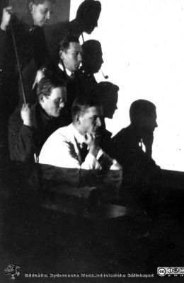 Fotoalbum tillägnat professor Torsten Hellman från histologikursen HT 1930
Fotoalbum  "TILL PROFESSOR TORSTEN HELLMAN MED TACK FRÅN DELTAGARNA I HISTOLOGIKURSEN HÖSTTERMINEN 1930".  Bildtext "Lek".  Jämför med den snarlika bilden i fil imgLA2250318ff299. Skuggspel med elever i projektorns ljus. Den var specialbyggd. Se bildfil 250426-005Cpg. Sådana apparater var vid denna tid annars inte vanliga. Foto troligen i mikroskoperingssalen.
Bildkälla stiftelsen Locus Medicus Lundensis och Sydsvenska Medicinhistoriska Sällskapet / SMHS. Fotograf okänd.
Nyckelord: Histologiska avdelningen;Anatomiska Institutionen;Medicinska fakulteten i Lund;Sydsvenska Medicinhistoriska Sällskapet;Locus Medicus Lundensis;Elever;Skuggspel