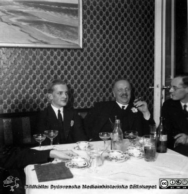 Fotoalbum tillägnat professor Torsten Hellman från histologikursen HT 1930
Fotoalbum  "TILL PROFESSOR TORSTEN HELLMAN MED TACK FRÅN DELTAGARNA I HISTOLOGIKURSEN HÖSTTERMINEN 1930".  Bildtext "EPILOG. Stämningen var den bästa redan fån början.".  Professor Torsten Hellman mellan två yngre medicinare. Foto kanske i professorns hem.
Bildkälla stiftelsen Locus Medicus Lundensis och Sydsvenska Medicinhistoriska Sällskapet / SMHS. Fotograf okänd.
Nyckelord: Histologiska avdelningen;Anatomiska Institutionen;Medicinska fakulteten i Lund;Sydsvenska Medicinhistoriska Sällskapet;SMHS;Locus Medicus Lundensis;Elever;Avslutningsfest