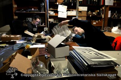 Från Medicinhistoriska Magasinet 2009
Medicinhistoriska Magasinet i februari 2009 under ambulansgaraget vid USiL. Alla tiotusentals saker lagrade i gamla Orupssjukuset är hitflyttade, och gallring pågår av arkivarier från Kulturen i Lund. Två arkivarier (Josefin Nilsson? och  Mats Engström) katalogiserar.
Nyckelord: Medicinhistoriskt magasin;USiL;Lasarettet;Universitetssjukhuset;Lund;Kulturen;2009;Lund;Mats Engström;Josefin Nilsson