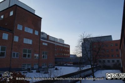 Till vänster norra sidan av onkologiska kliniken. I markplanet radiofysiska insitutionen.
 I bakgrunden Kampradhuset. Foto Berndt Ehinger 2010
Nyckelord: Radiologi;Onkologi;Universitetssjukhus;Lund;Radiofysik