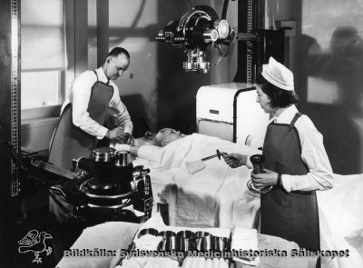 En röntgenundersökning med angiografi
Röntgen Omonterat foto. Troligen en reklambild från mitten av 1900-talet. Kassettväxlaren är av märket Schönander, en svensk firma som konstruerade och sålde röntgenutrustning.
Nyckelord: Röntgen;Angiografi;1900-talet;Kassettväxlare;Schönander;Kapsel 10
