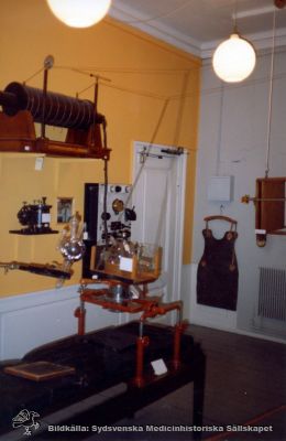 Utställning av gammal röntgenutrustning
Röntgenutrustning. Uställningsbild, rimligen från samma utställning som närliggande bilder tagna 1992. Foto Omonterat
Nyckelord: Utställningsbild;Apparatur;Utrustning;Röntgen;Undersökningsrum;Omonterat foto;Kapsel 10