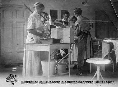 Gipsning på ortopediska kliniken i Lund före 1935.
Ortopedi. Ortopeden före 1935. 1. Docent Gunnar Frising, 2. Undersköterska Annie Persson, Stark 3. Översköterska Syster Elly ?. Gipsning av ben. Foto, skadat, omonterat
Nyckelord: Ortopedi; Gipsning; Ben; Frising; Gunnar; Docent; Annie; Persson; Undersköterska; Översköterska; Syster Elly; Omonterat fotografi; Kapsel 10