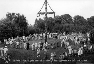 Midsommarfirande på Vipeholm
 Publicerad på sid. 32 i Carlén-Nilsson C, Holmér U (1998) Röster från Vipeholm. pp. 1-127 Stiftelsen medicinhistoriska museerna i Lund och Helsingborg, Lund. Bildtext där: "Minsommarfirandet var en av årets höjdpunkter". L. Christensson. Originalfoto? Omonterat
Nyckelord: Omonterat;Foto;Kapsel 14;Fest;Vipeholm;Midsommar;Christensson