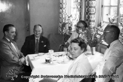 Fest på Vipeholms sjukhus. Stenvall (i mörk kostym) fyller år och firas. Dr Edvin Persson i mörka glasögon vid fönstret.
Vipeholm fester. Foto Omonterat
Nyckelord: Vipeholm;Fest;Kapsel 14;Foto;Omonterat;Personal;Kaffe;Edvin;Persson