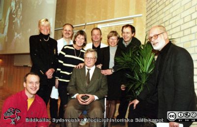 Malmö Allmänna Sjukhus 1999. Temadag på infektionskliniken i Jubileumsaulan
Album MAS 1998. IV. 1999. I. Från fotograf Björn Henrikssons samling. 00-10869. 1999-01-01. Temadag på infektionskliniken i Jubileumsaulan i samband med Stig Cronbergs pensionering. Från vänster: sjuksköt. Niklas Winqvist, Inga Odenholt (då klinisk lärare, nu professor), överläkare Sven Haidl, överläkare Ewa Wallmark, professor Stig Cronberg (sittande), överläkare Torbjörn Prellner, Marlene Wullt (disputerad),  kurator Magnus Andersson och smittskyddsläkaren Hans-Bertil Hansson. Från negativ.
Nyckelord: UMAS;MAS;Malmö_;Allmänna;Sjukhus;Infektion;Utbildning;Temadag;Uppvaktning;Pensionering