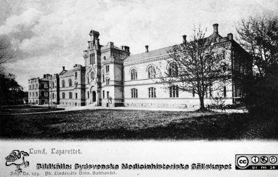 Vykort med foto av 1867/68 års kirurgiska klinik i Lund, från nordost. 
Utgivet av Ph Lindstedt universitetsbokhandel i Lund. Ögonkliniken till vänster byggdes 1884. Träd saknas ännu på planen till vänster om byggnaden, så bilden är rimligen tagen bara få år efter 1884. Från 35 mm repronegativ i lasarettsfotograferna i Lunds arkiv. Pärm "Gammalt A".
Nyckelord: Lund;Lasarett;Kirurgi;Klinik;Exteriör;Vykort;Universitet;Universitetssjukhus