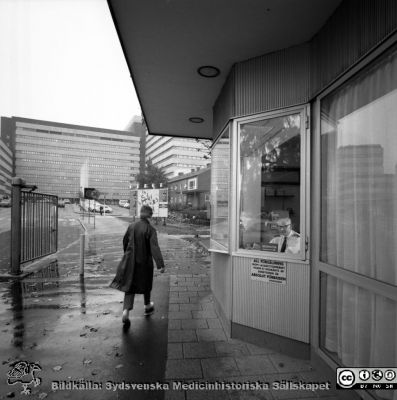 Portvakten vid Getingevägen i regnväder 1970.
USiL Pärm "Div. tagningar, 1960 och t.v.". 2 okt 1970. Bilder för "Aktuell information". Portvakten vid Getingevägen. Vy mot C-blocket, nybyggt 1968. Administrationshuset till vänster. Tandvårdskliniken till höger, bortom portvaktshuset. Från negativ
Nyckelord: Lund;Lasarett;Universitet;Universitetssjukhus;Entr;Portvakt;Grind;Blocket