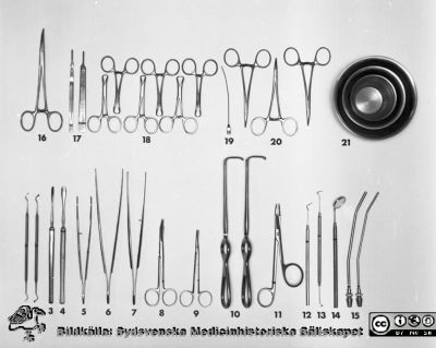 Tandläkarinstrument uppdukade 1969
Pärm "USiL div. tagningar. 1960 och t.v." Centraltandpol. 22/10, 1969. Tandl. Dahl, instrumentdukn. Från negativ. 
1. Excavator, liten
2. Excavator, stor
3. Elevatorium, smalt
4. Elevatorium, brett
5. Pincett, tand, 20 cm
6. Pincett, anatomisk, 20 cm
7. Pincett, klo, 20 cm
8. Sax, böjd spetsig, 12 cm
9. Sax, böjd enl. Ragnell, 12 cm
10. Hakar enligt Langenbeck 2 st
11. Nålförare enl. Gillies m sax, 16 cm
12. Sond, rak
13. Sond, böjd
14. Spegel
15. Sugrör 4 mm och 3 mm
16. Peang, liten böjd, anatomisk 16 cm
17. Skalpellskaft 16 cm, 2 st
18. Handduksklämmor 6 st
19. Spolkanyl
20. Peang
21. Rostfri kopp, 6,5, 9 och 12 cm
Nyckelord: Lund;Lasarett;Universitet;Universitetssjukhus;Oral;Kirurgi;Tandläkare;Dental