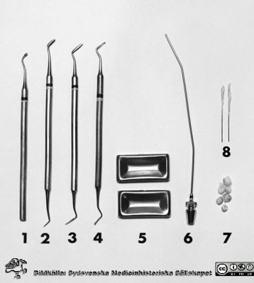 Instrumentsats för uppdukning på centraltandpolikliniken 1969
Pärm "USiL div. tagningar. 1960 och t.v.". Centraltandpol. 22/10 1969. Tandl. Dahl. instrumentdukn. Från negativ.
1. Kulstoppare, enkel
2. Carver enl. Wards
3. Cadrver enl. Nyström
4. Kulstoppare, liten
5. Medikamentprismor
6. Sugrör 1,5 diam.
7. Bomullspellets
8. Millernålar, bomullslindade
Nyckelord: Lund;Lasarett;Universitet;Universitetssjukhus;Dental;Tandpoliklinik;Tandläkare;Oral;Kirurgi;Instrument