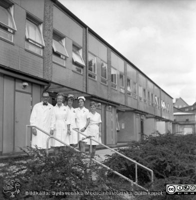 Infektionskliniken i Lunds chef,  docenten Karl Emil Thulin (1915 - 1999), med personal
Pärm "USiL div. tagningar. 1960 och t.v."- Infektionskliniken den 5 september 1969. Klinikchefen och docenten Karl Emil Thulin (1915 - 1999) utanför sin nybyggda klinik. Från negativ.
Nyckelord: Lund;Lasarett;Universitet;Universitetssjukhus;Infektion;Epidemi