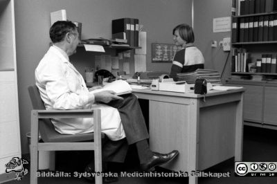 Neurologen professor Ragnar Müller 77-11-30 med en sekreterare på sin klinik
Lasarettet i Lund. Album "Svart/vitt negativ 1977. 2". 119. Från negativ.
Nyckelord: Lund;Lasarett;Universitetssjukhus;Universitet;USiL;Neurologi;Klinik;Administration;Styresman;Chefsläkare