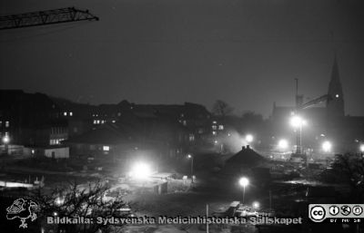 Lasarettet i Lund i början av 1960-talet. Nattbild söderut från dåvarande barnkliniken. 
Div. tagningar 1960 och t.v. Från negativ. Lasarettet i Lund i början av 1960-talet. Rimligen vid jultid (det finns en illuminerad julgran på annan bild i denna serie). Nattlig utsikt över bygget av ny infektionslklinik. Allhelgonakyrkan i bakgrunden. Till vänster kanske markarbeten för radiologiska klinikens utbyggnad.
Nyckelord: Lund;Lasarett;Universitetssjukhus;Universitet;USiL;Infektion;Epidemi;Bygge