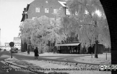 Ortopediska kliniken och lasarettskiosken en rimfrostdag på 1960-talet
Lasarettsfotograferna. Lund. Pärm "Div. tagningar, 1960 och t.v.". Lasarettets exteriörer. Vy norrut från mot ortopediska kliniken och lasarettskiosken en rimfrostdag 1961. AB-blocket skymtar i bakgrunden. Från negativ.
Nyckelord: Lasarett;Lund;Universitet;Universitetssjukhus;USiL;Ortopedi;Kiosk;Rimfrost;Vinter
