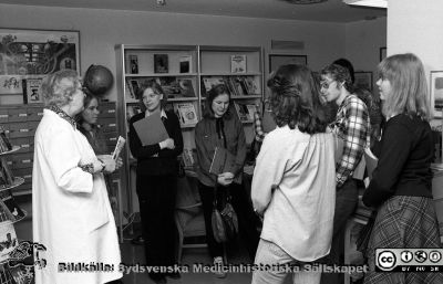 Sjukhusbibliotekarie Brita Arborelius med amerikanska besökare, rimligen studenter
Sjukhusfotograferna i Lund. Pärm Negativ 1979:1. 50B. Foto 79-03-08. Från negativ.
Nyckelord: Lasarettet;Lund;Universitetssjukhus;USiL;Bibliotek;Bibliotekarie;Besök;Amarikanska;Besökare