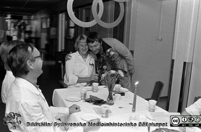 Olympisk guldmedalj till anställd på Lasarettet i Lund
Sjukhusfotograferna i Lund. Pärm negativ, S/V. 1976.	122. Bodil Elg (f. 1937), guldmedaljör vid Paralympics i Toronto sommaren 1976 i bågskytte, gratuleras till sina framgångar på kliniskt kemiska laboratoiret i Lund där hon arbetade. Gratulanten är inköposchefen Bertill Widell. Den hiterste mannen vid bordet tf klinikchefen i klinisk kemi, docent Bengt Johansson. Från negativ.
Nyckelord: Lasarettet;Lund;Universitet;Universitetssjukhus;USiL;Laboratorium;Guldmedalj;Paralympics;Handikapp;Olympiad