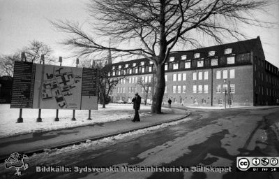 Söderfasaden på gamla kvinnnokliniken
Sjukhusfotograferna i Lund. Pärm Negativ, S/V. 1976. 32. Söderfasaden på gamla kvinnnokliniken, nu på väg att tömmas när verksamheten flyttade till nyrenoverade lokaler i gamla ortopediska klinikens hus. Allhelgonakyrkan till vänster i bild. En orienteringstavla i förgrunden. Från negativ. 
Nyckelord: Lasarettet;Lund;Universitet;Universitetssjukhus;USiL;Kvinnoklinik;Gynekologisk;BB;KK;Orienteringstavla