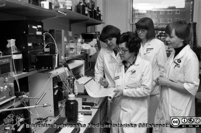 Personal på Avldeningen för klinisk farmakologi 1980
Sjukhusfotograferna i Lund.Pärm Negativ, -80:1. 39b. Från vänster till höger: Laboratorieassistent IngBritt Mårtensson, ingenjör Sonja Helgesen med penna i hand vid skrivaren, laboratorieassistent Gertrude Persson och laboratoriesjuksköterskan Stina Ragnarsson. Från negativ.
Nyckelord: Lasarettet;Lund;Universitetssjukhus;USiL;Klinisk;Farmakologi;Avdelning;Laboratorium