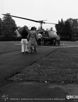 Helikopter på plattan vid Gamla Seminariet 1980
Sjukhusfotograferna i Lund. Pärm Negativ, 80:1.	89. Helikopterlandning med maskin från flygvapnet på plattan strax väster om Gamla Seminariet. Första försöket. Det blev inte många fler, om några. 80-10-16. Från negativ.
Nyckelord: Lasarettet;Lund;Universitetssjukhus;USiL;Räddningstjänst;Helikopter;Helikopterplatta