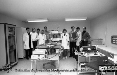 Bertil R. Perssons forskargrupp i radiofysik i Lund 1984
Sjukhusfotograferna i Lund. Pärm S/V neg-84.	31. 84. 18x24. Den grupp som som konstruerade och byggde Skandinaviens första MR kamera (0,07 tesla)  i Lund 1983-84, embryot till den 7 tesla MR kamera som 2015 installerades i Lund. Maskinen nu i en monter vid entrén till 7 T avdelningen bakom akuten. Från vänster Lennart Bertenstam (ingenjör), Börje Blad (ingenjör), Freddy Ståhlberg (doktorand), Magnus Olsson (doktorand), Kjell-Åke Carlsson (instrumentmakare), Elna-Marie Larsson (röntgenolog), Bertil Persson (professor), Lars Malmgren (forskningsingenjör), (Stefan Pettersson doktorand). Från negativ
Nyckelord: Lasarett;Lund;Universitet;Universitetssjukhus;USiL;Radiofysik;MR;Magnetröntgen