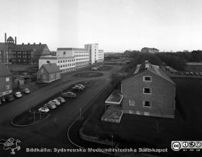 Norra lasarettsområdet har börjat utvidgas, 1958
Pärm Lasarettsfoto, interiörer och exteriörer m.m. 1958 - 1960. Det nybyggda AB-blocket 1958. Folkskoleseminariet till vänster i bilden. Tandkliniken nere till höger i bilden. Psykiatriska kliniken uppe på backen vid horisonten. Administrationsbyggnaden syns ännu inte, men har just börjat byggas (till vänster utanför bilden). Foto från någon av de översta våningarna på dåvarande barnkliniken. Från negativ.
Nyckelord: Lasarettet;Lund;Universitet;Universitetssjukhus;USiL;Blocket;Folkskoleseminariet;Barnkliniken;Pediiatrisk;Klinik