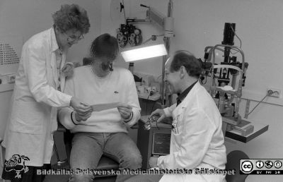 Syncentralen i Lund
Sjukhusfotograferna i Lund. Pärm Negativ, Dia, 1987.51/1987. B. 87-04-06. Ögonläkaren Gudrun Brismar hjälper en synskadad patient tillsammans med optiker Ove Devenius. Från negativ. 
Nyckelord: Lasarettet;Lund;Universitetssjukhus;USiL;Syncentralen;Synhjälp;Ögon;Klinik;Oftalmologisk;Oftalmiatrisk;Synskadad