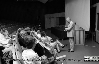 Administrativa chefer inför ett möte i aulan på Centralblocket i Lund
Sjukhusfotograferna i Lund. Pärm Svart-vita neg. 1987. 105/-87. 87-08-24. Stående sjukhusdirektör Kurt Roos. Bland de sittande syns bl.a Thomas White, Mark Blomberg. Hans Rorsman och Ingvar Wiberg. Från negativ. 
Nyckelord: Lasarettet;Lund;Universitetssjukhus;USiL;Administration;Chefer;Möte