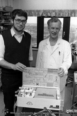 Professorn i medicinsk teknik Nils Gunnar Holmer och anestesiologen, docent Lars Nordström och med en ServoVentilator1987
Sjukhusfotograferna i Lund. Pärm Svart-vita neg. 1987. 146/87. Foto i januari 1988.
Nyckelord: Lasarettet;Lund;Universitetssjukhus;USiL;Anestesi;Medicinsk;Teknisk;Klinik;Avdelning;MTA;Ventilator;Respirator