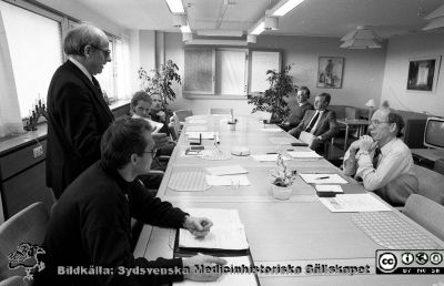 Diplom och medaljer delas ut för arbetarskydsarbete på Lasarettet i Lund 1988
Sjukhusfotograferna i Lund. Pärm Sv/v neg. 1988. 88-12-07. Direktionens ordförande, Fredrik Swartling nr 2 från vänster runt bordet. På samma sida sitter representanter för Föreningen för Arbetarskydd med diplom och medaljer att dela ut; kanske Harry Schiffman och längst bort BMA Bengt Jönsson, huvudskyddsombud för vårdförbundet. På andra sidan bordet, bortifrån: narkosläkare Lars Nordström, sjukhusjurist Matts Wendel, elektriker Börje Lundberg. Ekonom Lillemor Gregorius skall just få sitt diplom och sin medalj, men sitter gömd bakom elektrikern Börje Lundberg som just fått sina utmärkelsetecken. Från negativ.
Nyckelord: Lasarettet;Lund;Universitetssjukhus;USiL;Arbetarskydd;Förening;Direktion;Medalj;Diplom;Utmärkelse