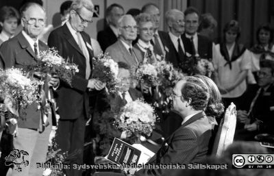 Forskningens Dag 1988
Sjukhusfotograferna i Lund. Pärm Sv/v neg. 1988. 75. IV/88. Fernströmssymposium "Att sova och att drömma" på Forskningens Dag. Alla pristagarna samlade för att hyllas. På främsta raden i auditoriet H. M. kung Carl XVI Gustaf  I bakgrunden studentsångare, Ingegärd Lindqvist (ansvarig för arrangemangen) och ett par mötesvärdinnor, bl.a. Gunilla Sernelin. Från negativ.
Nyckelord: Lasarettet;Lund;USiL;Universitetssjukhus;Forskningens;Dag;Symposium;Prisutdelning