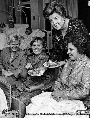 Socioterapi i senare delen av 1900-talet
Bilder från sjukhusprästen Bernt Eriksson, 1960 - 2000-talen. Journalisten, TV- och radioprofilen Ria Wägner bjuder på handelsmannen Sigfrid Ljunggrens delikatesstallrik vid en afton i "Träffpunkten". Från foto. 
Nyckelord: Lasarettet;Lund;Universitetssjukhus;USiL;Socioterapi;Television;Radio;Kyrka
