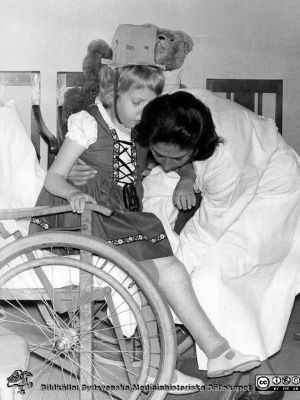 Barn i rullstol med svullet ben får hjälp av dr Helena Svantesson f. Zymler
Bilder från sjukhusprästen Bernt Eriksson, 1960 - 2000-talen. Omärkt bild. Foto på 1970-talet. Från foto. 
Nyckelord: Lasarettet;Lund;Universitetssjukhus;USiL;Reumatologisk;Klinik;Barn