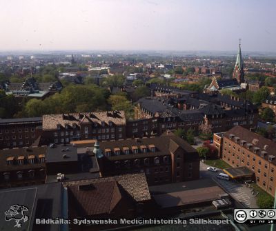 Utsikt söderut från centralblocket på Lasarettet i Lund
Utsikt över nya kvinnokliniken, reumatologiska kliniken och gamla medicinska kliniken i Lund (nu hudhuset) med Allhelgonakyrkan i bakgrunden. Foto troligen nära sekelskiftet 2000, troligast från centralblocket.
Nyckelord: Lasarettet;Lund;Universitetssjukhus;USiL;Hud;Dermatologisk;Reumatologisk;Kyrka;Allhelgona;_Öron;_ÖNH
