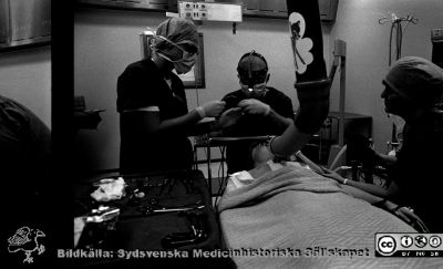 En operation på öronkliniken 1990
Pärm Lasarettsfotograferna i Lund, Pärm negativ, 1990. 12. 1990. En operation på tonsillerna (en s.k. abrasio) på öronklinikens operationsavdelning 1990-02-02. 2812. Operatör: kanske Ingvar Eliasson. Undersköterskan Eva-Lena assisterar liksom narkosläkaren Annika Beskow. Från negativ.
Nyckelord: Lasarettet;Lund;Universitetssjukhus;USiL;Oto-rino-laryngologisk;_Öron;Klinik;Anestesi;Narkos;Operation;_ÖNH;Abrasio;Tonsiller