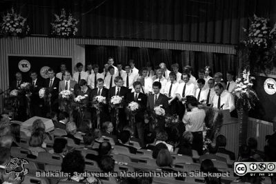 Forskningens dag 1992
Lasarettsfotograferna i Lund, pärm S/V negativ, 1992. 33. De yngre pristagarna hyllas av Lunds Studentsångförening, anförda av Carl-Håkan Larsén (närmast talarstolen). Pristagarna är från vänster: Roger Henriksson (Umeå), Rikard Holmdahl och Stefan Sandeler (Uppsala), Björn Vennström (Stockholm), Karin Fälth-Magnusson och Tommy Sundqvist (Linköping), Patrik Rorsman och Göran K. Hansson (Göteborg) och Tadeusz Wieloch (Lund). Från negativ.
Nyckelord: Lasarettet;Lund;Universitetssjukhuset;USiL;Ferström;Forskningens;Dag;Pristagare