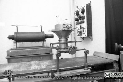 Röntgenutställning på medicinhistoriska museet på St Lars 1995
Lasarettsfotograferna i Lund,  pärm S/V Neg. 1995. 62. 95-06-28. Röntgenutrustning från c:a 1910: brits av trä, kokarrör i trähållare, högspänningsspole av Ruhmkorfftyp, reglerutrustning. Från negativ.
Nyckelord: Lasarettet;Lund;Universitetssjukhuset;USiL;Radiologi;Rtg;Röntgen;Medicinhistorisk;Utställning