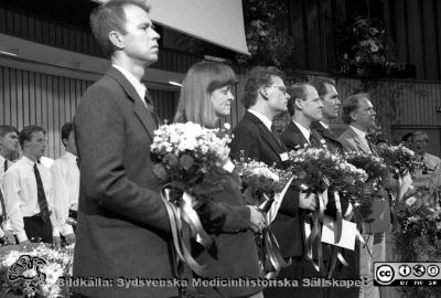 Forskningens Dag 1995
Lasarettsfotograferna i Lund,  pärm S/V Neg. 1995. 77. Forskningens dag, 95-11-01. De yngre mottagarna av Fernströmspris (från vänster Martin Gullberg, Lena Claesson-Welsh, Per-Olof Berggren, Thomas Skogh, Christer Betsholtz och Bo Åkerström) yllas av Lunds Studentsångförening för sina insatser. Från negativ.
Nyckelord: Lasarettet;Lund;Universitetssjukhuset;USiL;Forskningens Dag;Utställning;Symposium;Konferens;Hyllning;Pristagare