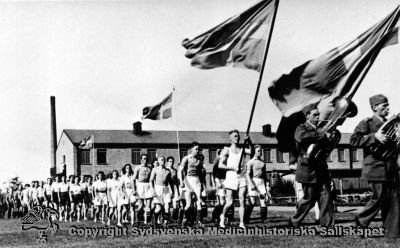 Uppmarsch till klingande spel vid invigningen av Vipeholms idrottsplats år 1942.
Vipeholm Idrottsklubb. Foto Omonterat
Nyckelord: Idrottsklubb;Vipeholm;Kapsel 15;Omonterat;Foto;Uppmarsch;Ingvigning;Idrottsplatsen;1942;Marsch;Musik